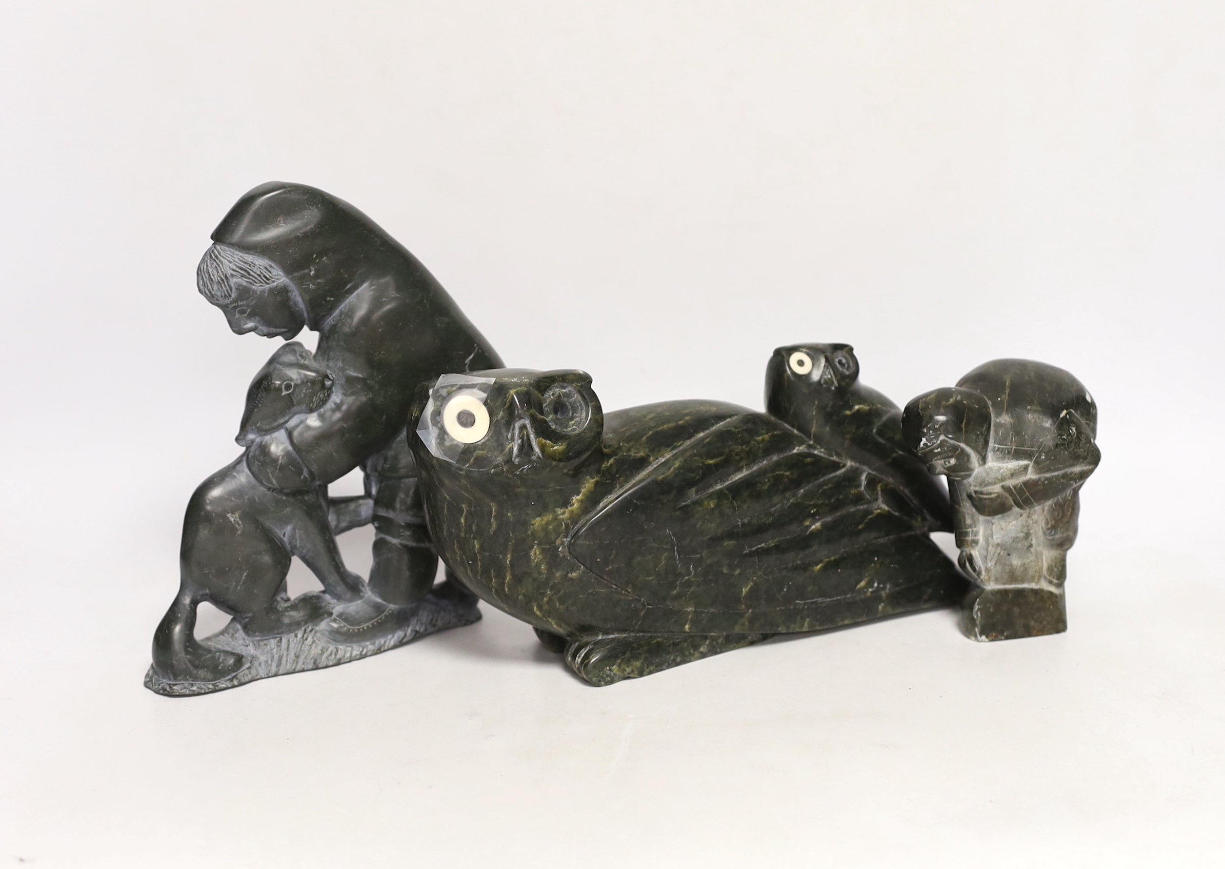 Three 20th century Inuit stone figural carvings, one bearing marine bone eyes, largest 19cm high